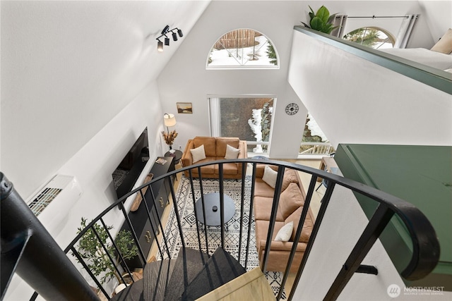 stairway with high vaulted ceiling and rail lighting