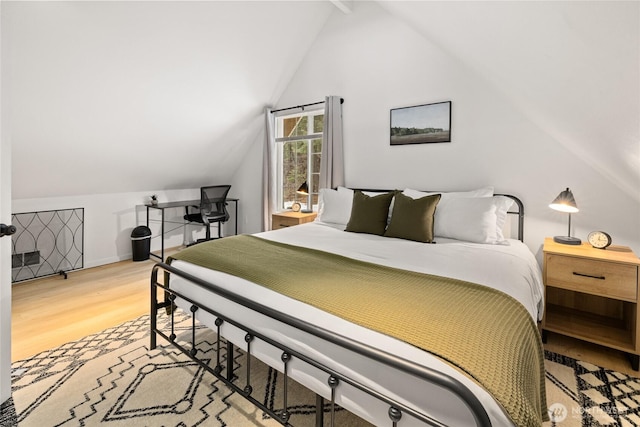 bedroom with vaulted ceiling and light wood-style flooring