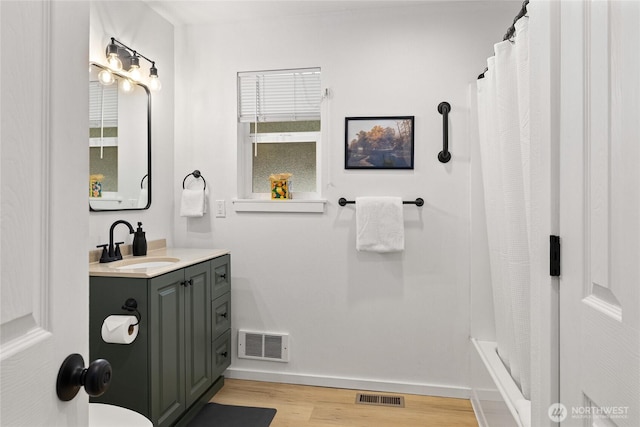 bathroom with curtained shower, visible vents, wood finished floors, and vanity