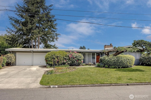 view of front of home featuring an attached garage, concrete driveway, and a front lawn