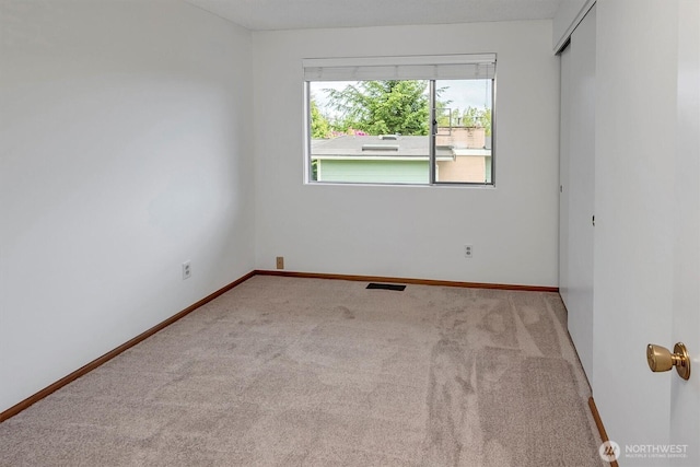 spare room featuring carpet flooring and baseboards