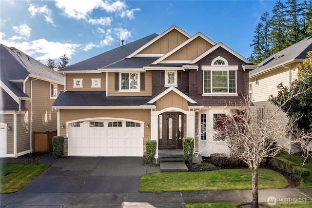 craftsman inspired home featuring a shingled roof, concrete driveway, an attached garage, board and batten siding, and fence