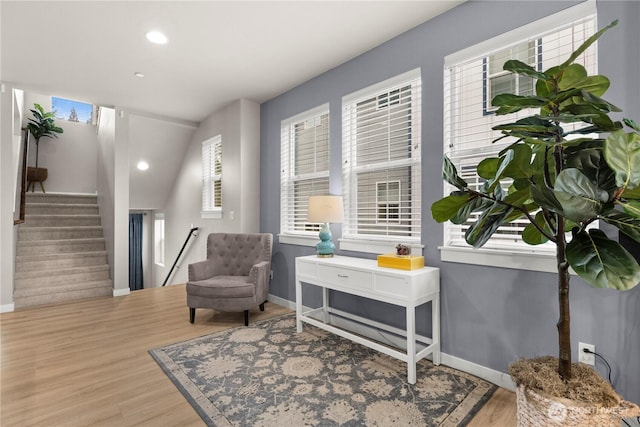 living area with stairway, baseboards, and wood finished floors