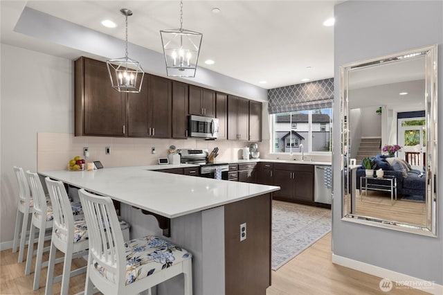 kitchen featuring a sink, stainless steel appliances, dark brown cabinets, and decorative backsplash