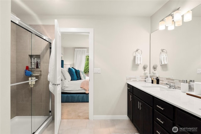 full bathroom with ensuite bathroom, backsplash, a shower stall, baseboards, and vanity