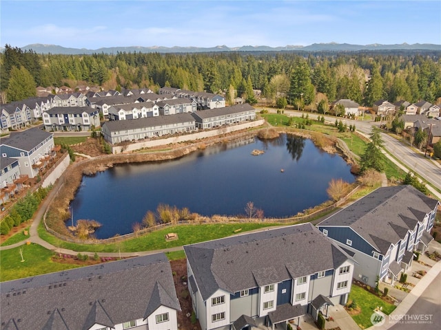 aerial view featuring a residential view, a wooded view, and a water and mountain view