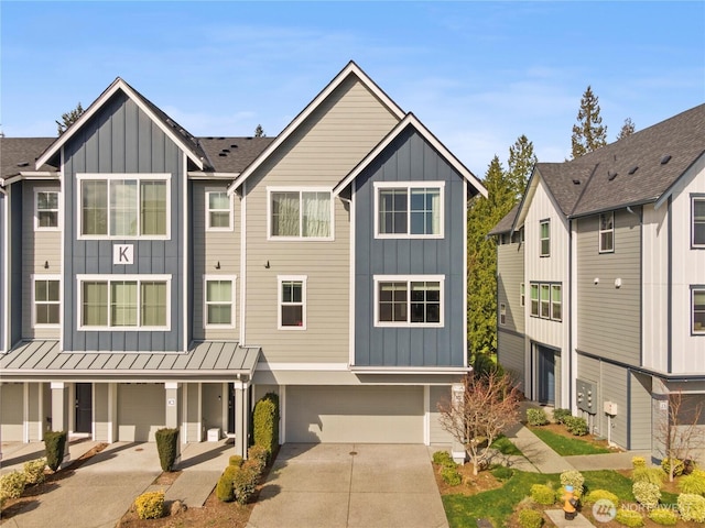 townhome / multi-family property featuring driveway, a standing seam roof, board and batten siding, metal roof, and a garage