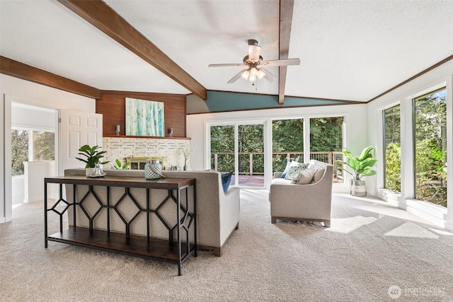 living room featuring a glass covered fireplace, carpet flooring, vaulted ceiling with beams, and a textured ceiling