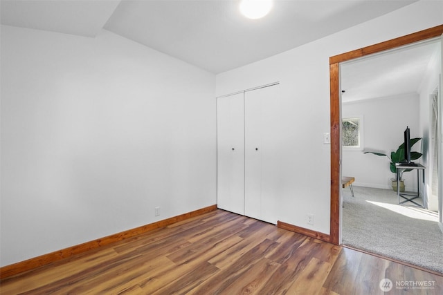 unfurnished bedroom featuring a closet, baseboards, and wood finished floors