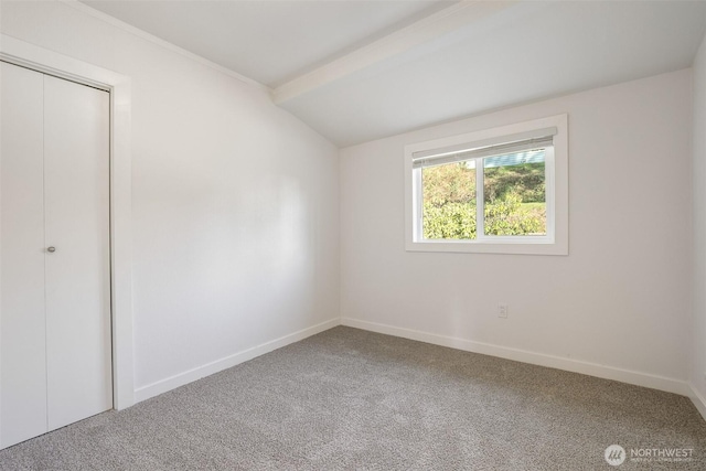 unfurnished bedroom featuring carpet floors, baseboards, a closet, and lofted ceiling