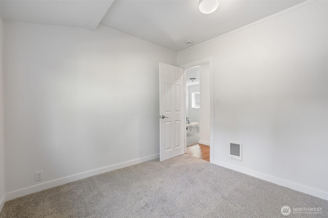 unfurnished room with visible vents, light carpet, and baseboards