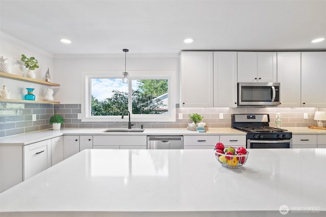 kitchen with stainless steel appliances, white cabinetry, a sink, and decorative backsplash