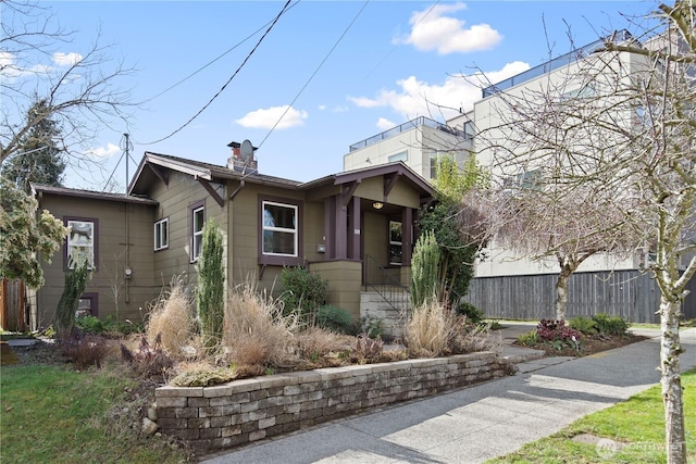 view of front of house with a chimney and fence