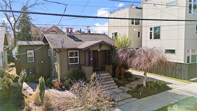 view of front of house with roof with shingles and a chimney