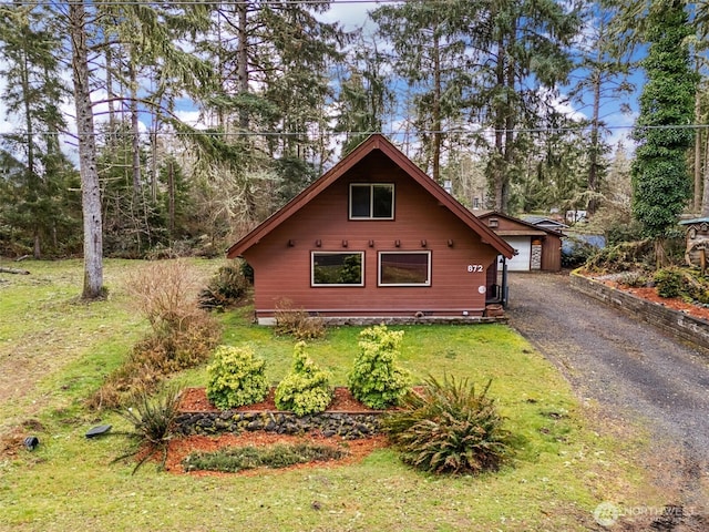 view of side of home with a lawn and an outdoor structure