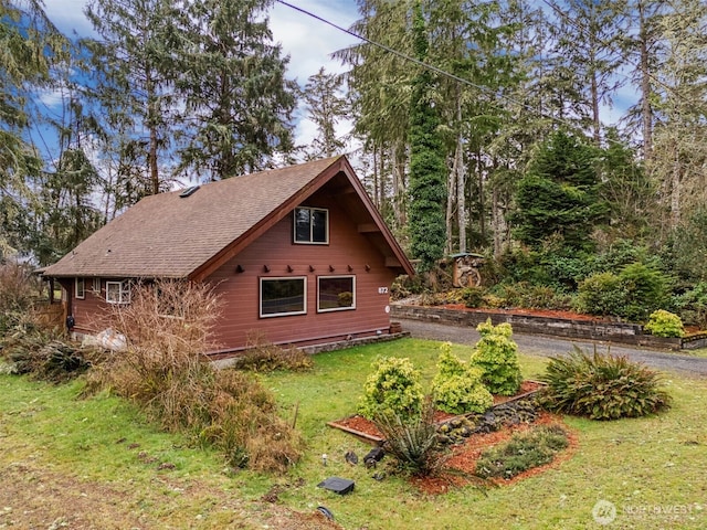 view of property exterior with a lawn and roof with shingles