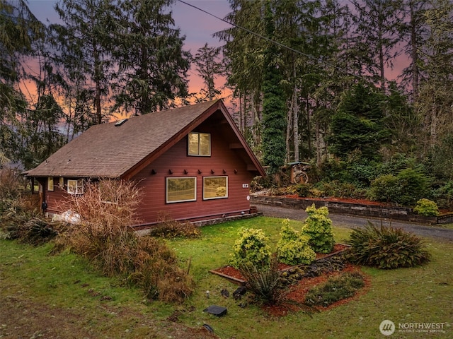 exterior space with a yard and a shingled roof