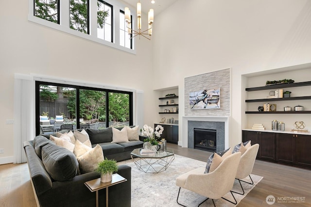 10906 SE 28th St, Bellevue, WA 98004 - living area featuring a tiled fireplace, built in features, an inviting chandelier, and light wood-style floors