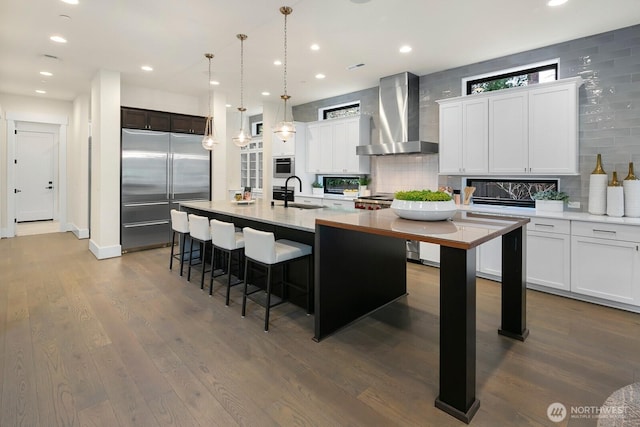 10906 SE 28th St, Bellevue, WA 98004 - kitchen with tasteful backsplash, dark wood-style flooring, a sink, wall chimney range hood, and appliances with stainless steel finishes