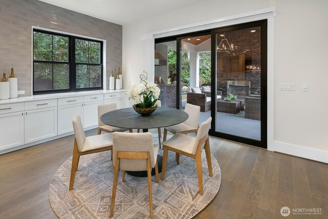 10906 SE 28th St, Bellevue, WA 98004 - dining room with baseboards, a fireplace, wood finished floors, and plenty of natural light