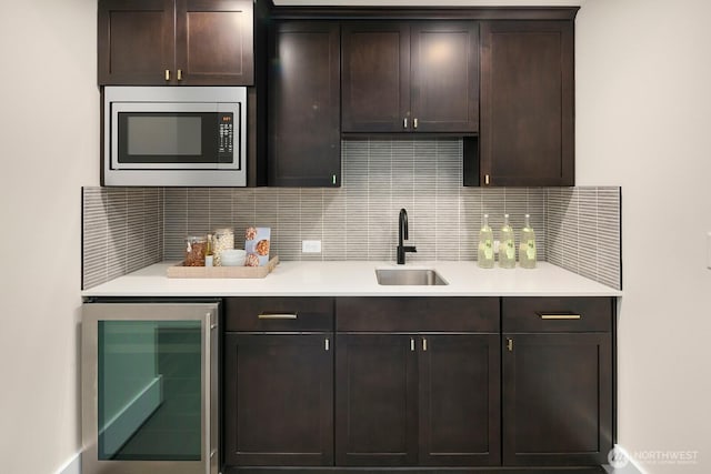 10906 SE 28th St, Bellevue, WA 98004 - kitchen featuring light countertops, stainless steel microwave, wine cooler, decorative backsplash, and dark brown cabinetry