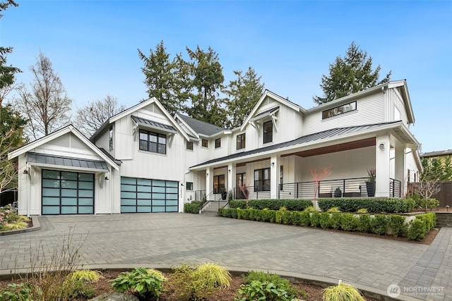 10906 SE 28th St, Bellevue, WA 98004 - modern farmhouse featuring a standing seam roof, an attached garage, metal roof, decorative driveway, and a porch