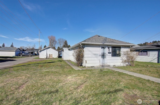 view of front of property featuring a front lawn and roof with shingles