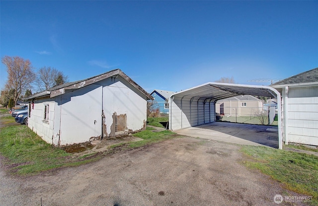 view of home's exterior with driveway and a detached carport