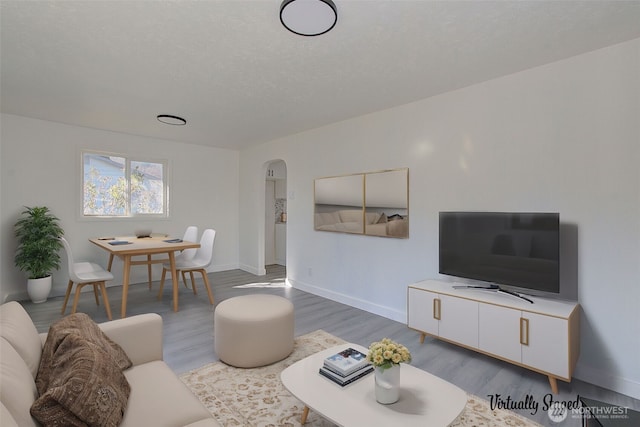 105 Redpath St, Kelso, WA 98675 - living area with wood finished floors, arched walkways, baseboards, and a textured ceiling