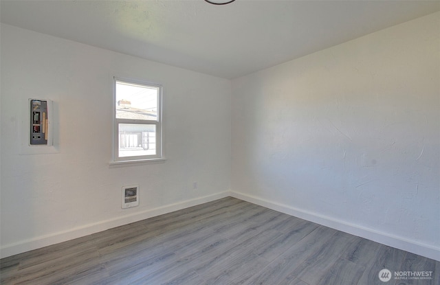 105 Redpath St, Kelso, WA 98675 - unfurnished room featuring baseboards, wood finished floors, and heating unit