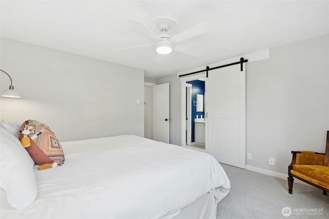 carpeted bedroom with a barn door, baseboards, and a ceiling fan