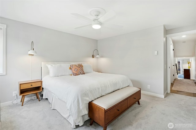 bedroom featuring a ceiling fan, light colored carpet, and baseboards