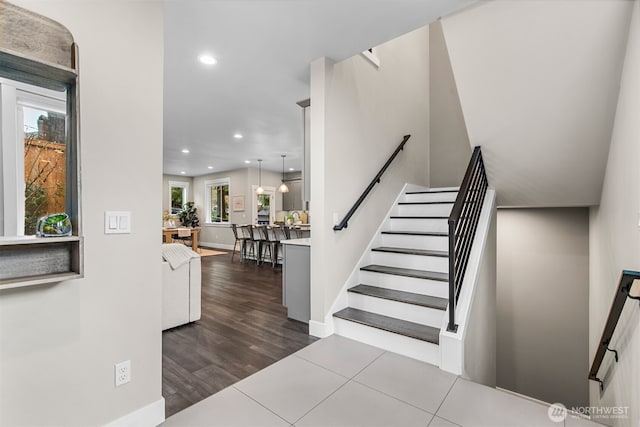 stairs featuring baseboards, wood finished floors, and recessed lighting