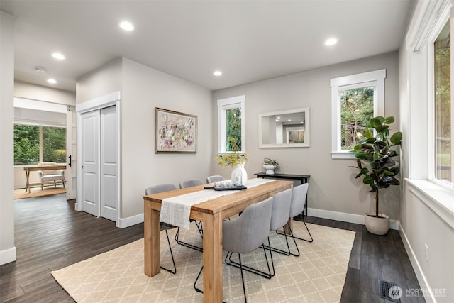 dining space with baseboards, wood finished floors, and recessed lighting