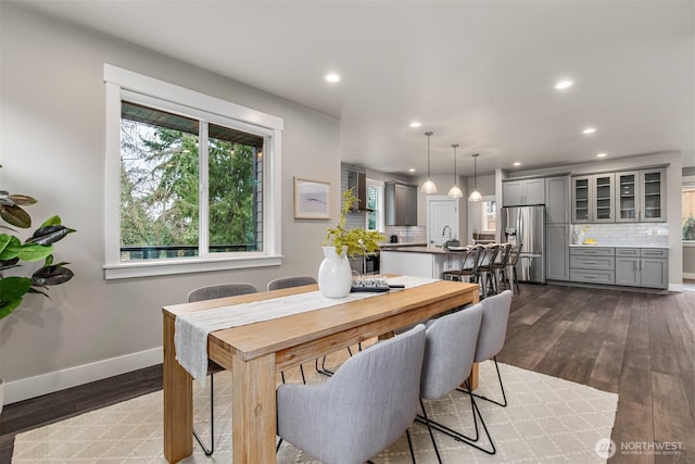 dining area with dark wood-type flooring, recessed lighting, and baseboards