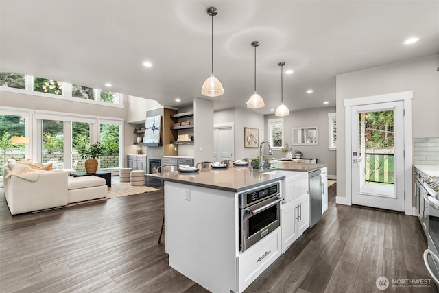 kitchen with dark wood-style floors, white cabinetry, appliances with stainless steel finishes, and a wealth of natural light