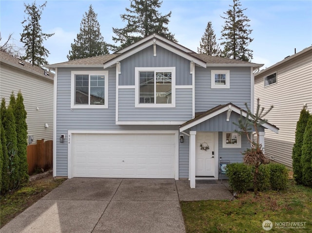 view of front of house with board and batten siding, fence, a garage, and driveway