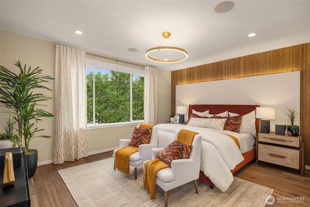 bedroom with recessed lighting, wood finished floors, and baseboards