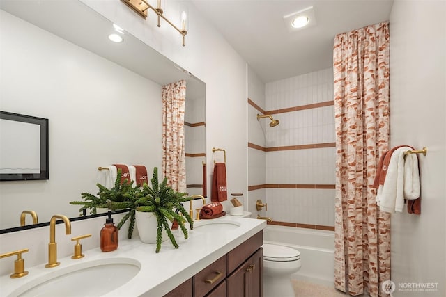 bathroom featuring shower / bath combination with curtain, double vanity, a sink, and toilet