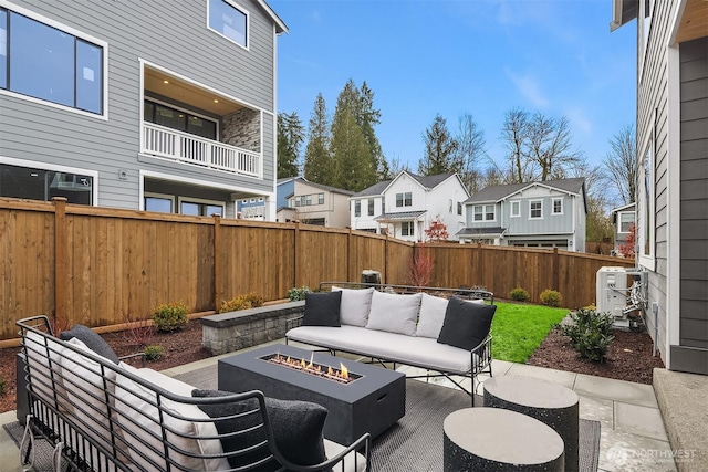 view of patio featuring a fenced backyard, an outdoor living space with a fire pit, and a residential view