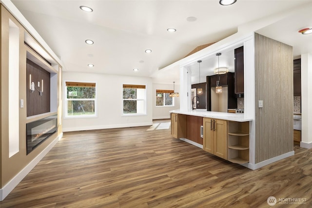 kitchen with stainless steel refrigerator, open shelves, light countertops, lofted ceiling, and dark wood-style flooring