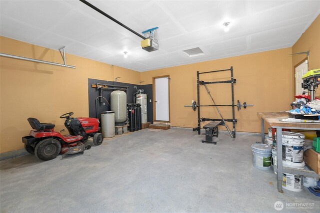 garage with water heater and a garage door opener