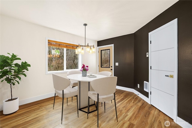 dining space featuring a chandelier, visible vents, light wood-style flooring, and baseboards