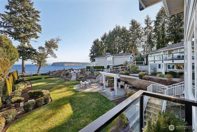 view of yard featuring a patio, a water view, and fence