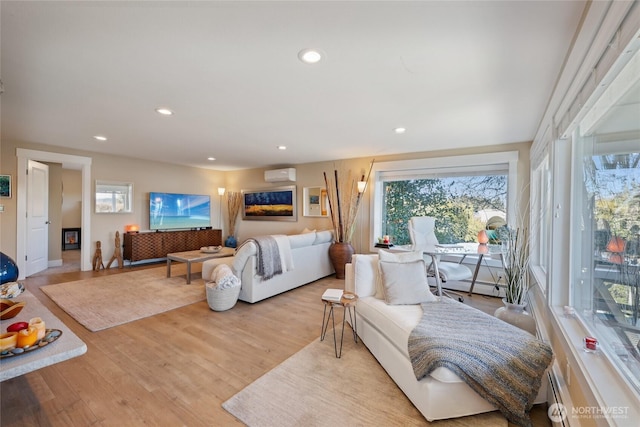 living area with a wall mounted AC, baseboard heating, wood finished floors, and recessed lighting