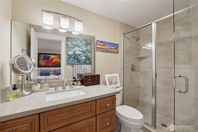 bathroom featuring toilet, a shower stall, and vanity