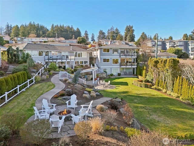 back of property with an outdoor fire pit, a residential view, fence, and a patio