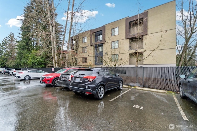 uncovered parking lot featuring fence