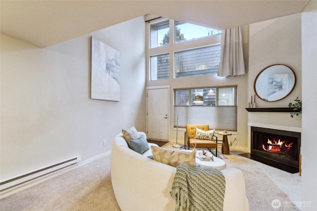 living room featuring a baseboard heating unit, baseboards, a fireplace with flush hearth, carpet flooring, and a towering ceiling