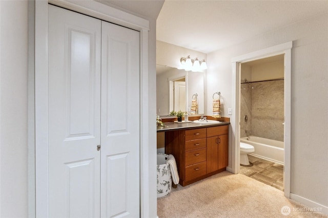 full bath with baseboards, toilet, vanity, and bathtub / shower combination